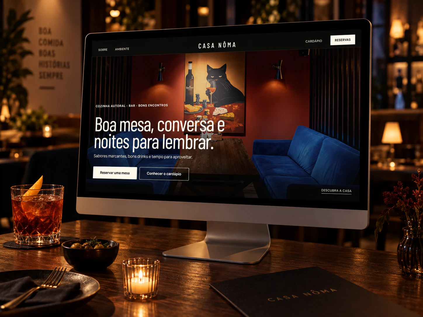 Projeto do site Casa Nôma exibido em um monitor dentro de um bar-restaurante intimista